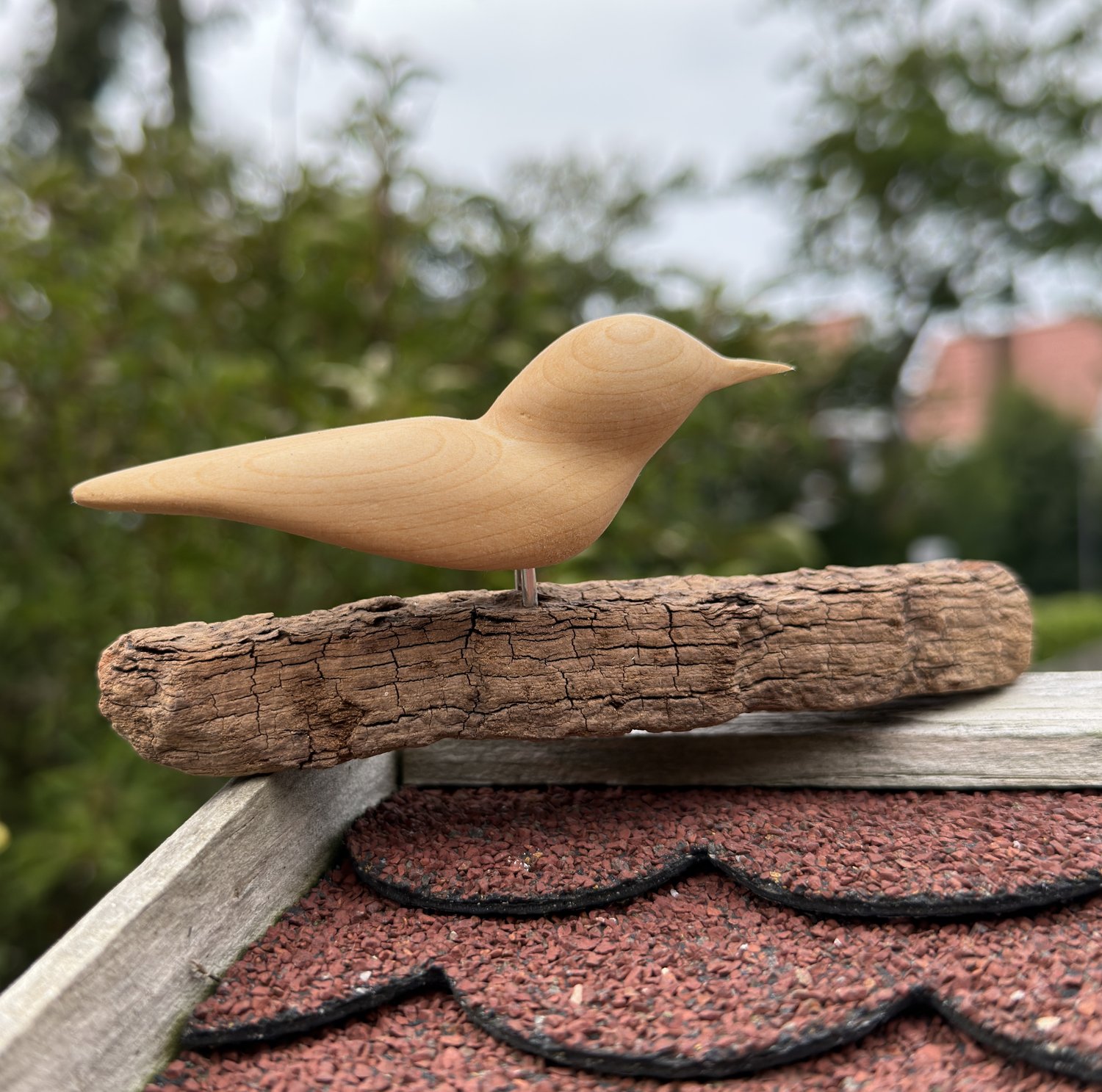 Handgemaakt houten geluksvogeltje op drijfhout